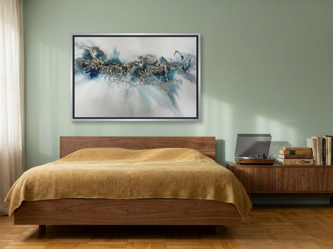 Canvas wall art with a silver leaf surround styled on the wall in a mid-century bedroom