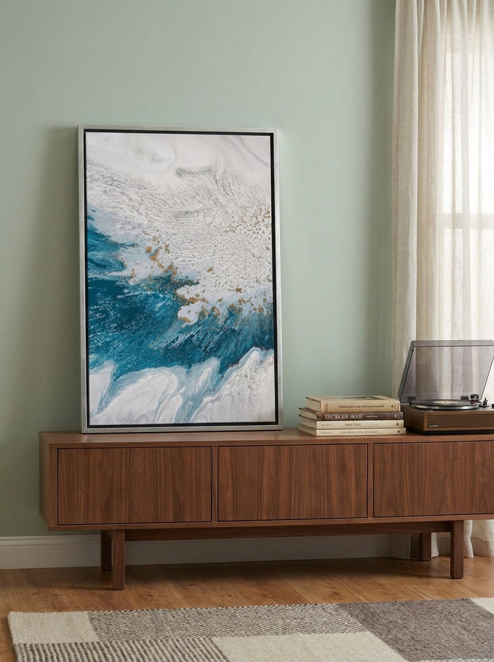 Canvas wall art with a silver leaf surround standing on a sideboard in a mid-century bedroom