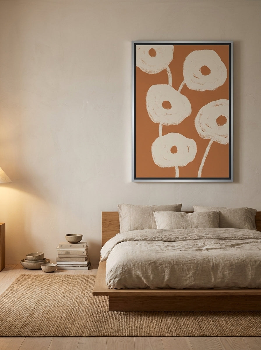 Canvas wall art with a silver leaf surround styled on the wall in a warm Japandi bedroom