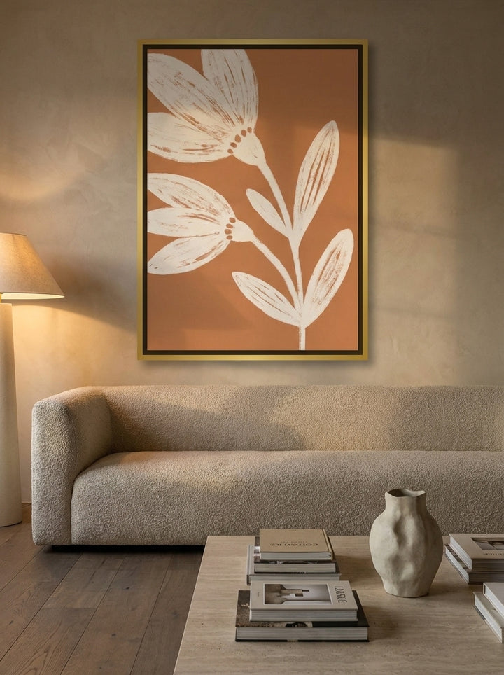 Oversized statement canvas wall art with a gold leaf surround styled on the wall in a luxe living room