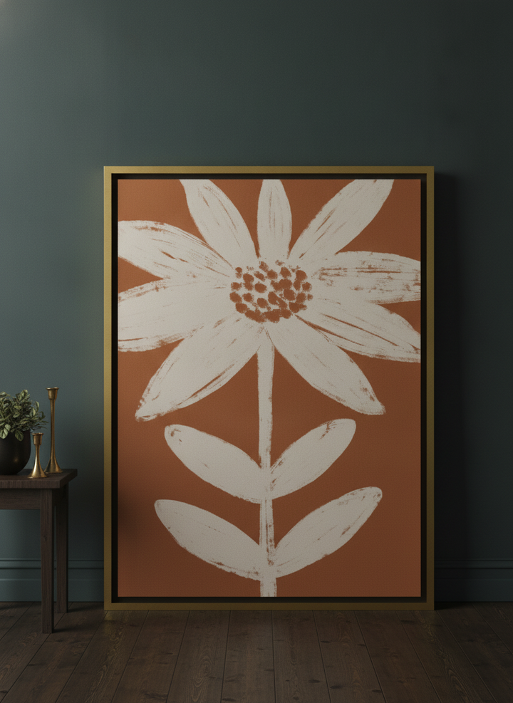 Oversized statement canvas wall art with a gold leaf surround leaning against the wall in a moody living room