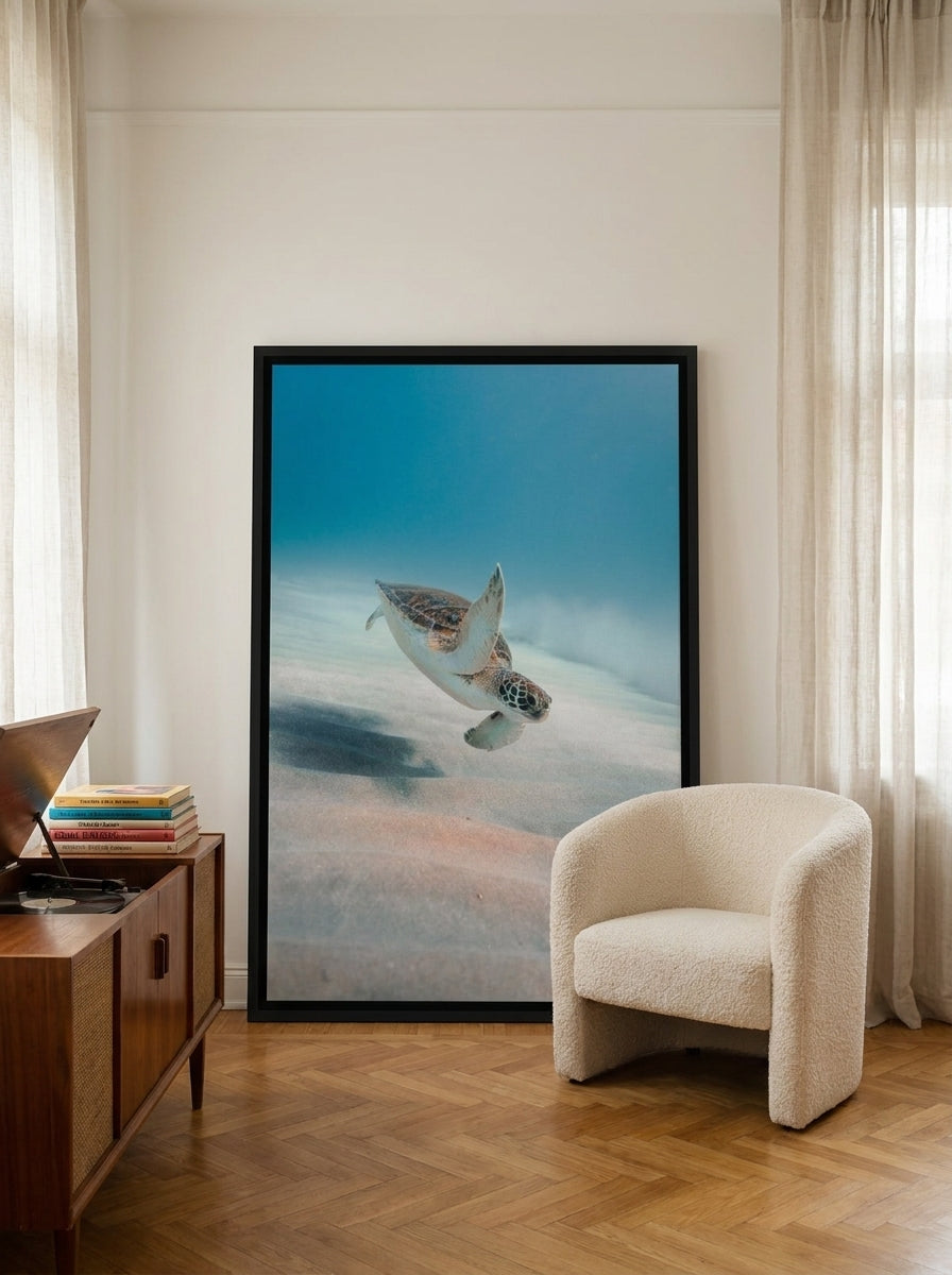 Oversized statement canvas wall art with a black surround leaning against the wall in a mid-century living room