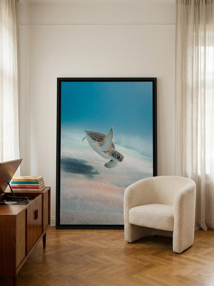 Oversized statement canvas wall art with a black surround leaning against the wall in a mid-century living room