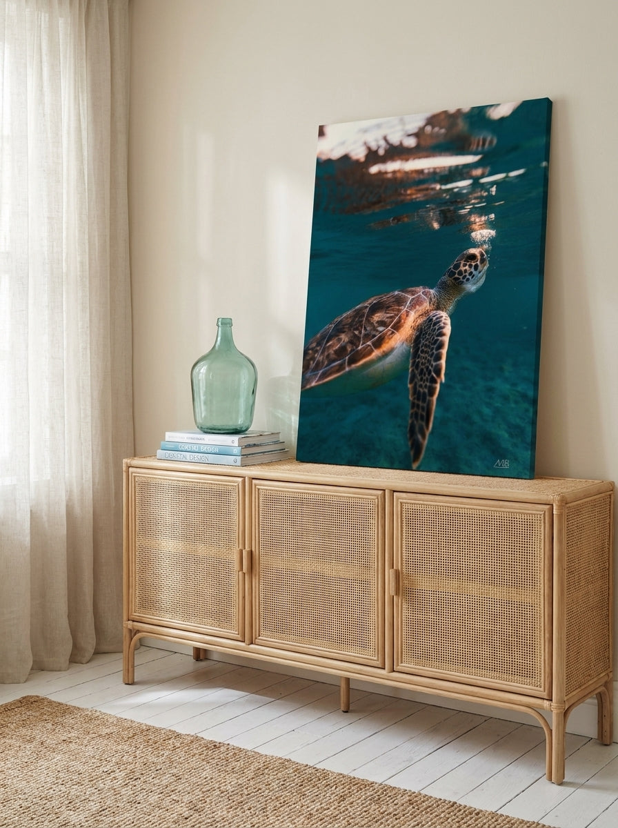 Stretched canvas wall art standing on a sideboard in a coastal living room