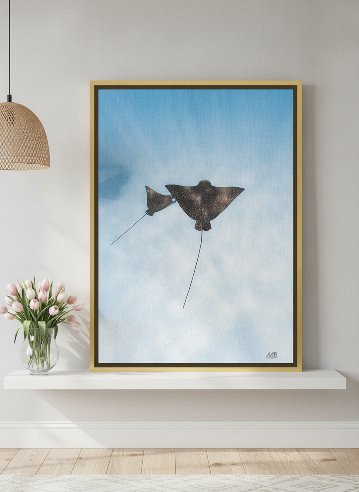 Canvas wall art with a gold leaf surround standing on a shelf in a bright Scandinavian bathroom