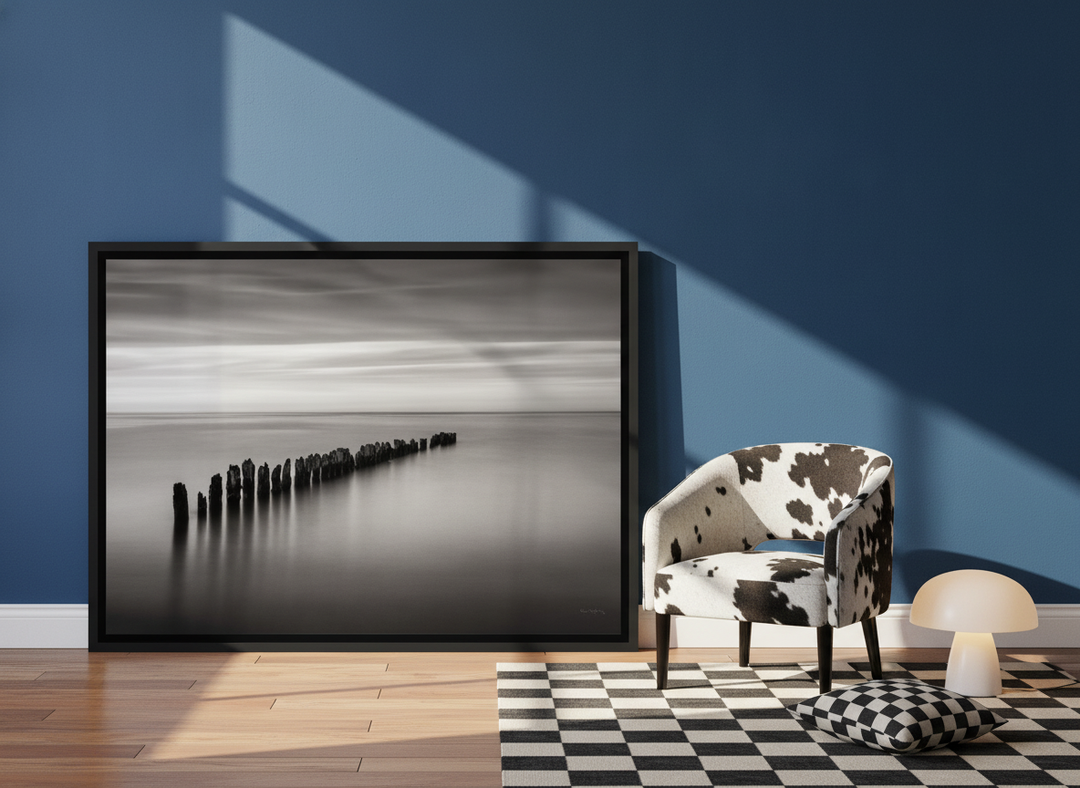Canvas wall art with a black surround leaning against the wall in a colourful eclectic living room