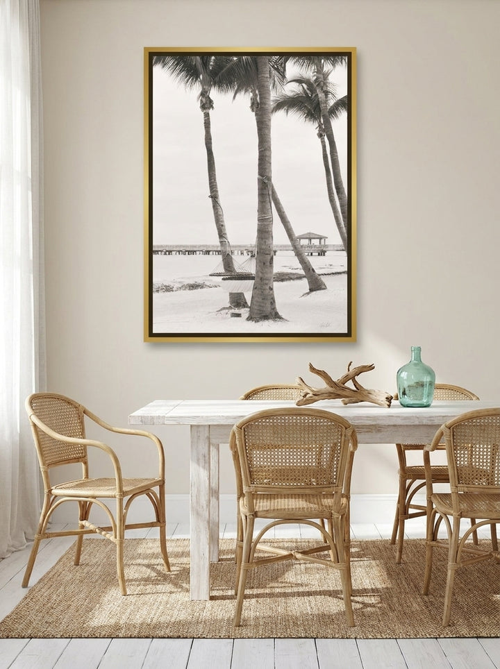 Canvas wall art with a gold leaf surround styled on the wall in a coastal dining room