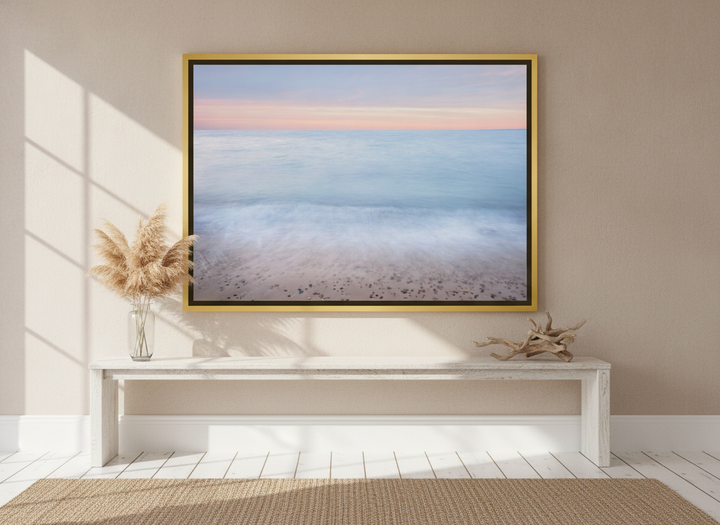 Oversized statement canvas wall art with a gold leaf surround styled on the wall in a coastal living room