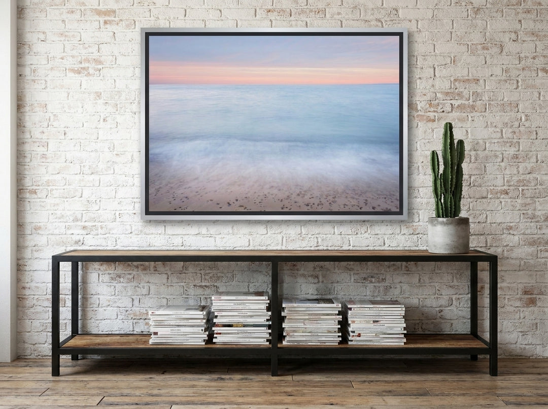 Canvas wall art with a silver leaf surround styled on the wall in an industrial loft living room