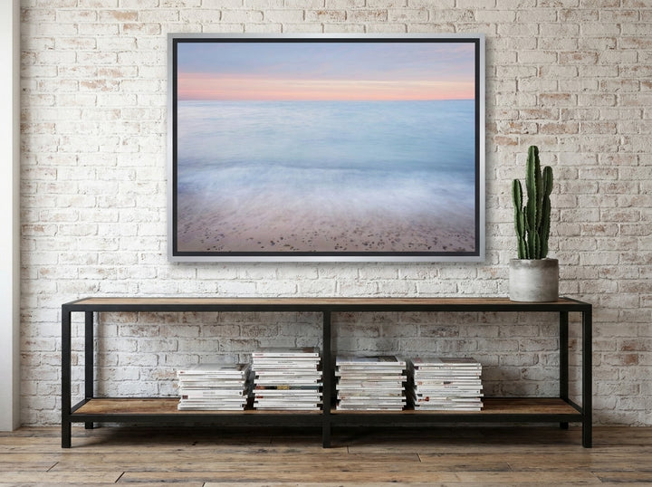 Canvas wall art with a silver leaf surround styled on the wall in an industrial loft living room