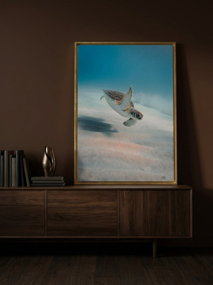 Canvas wall art with a gold leaf surround standing on a sideboard in a moody home office