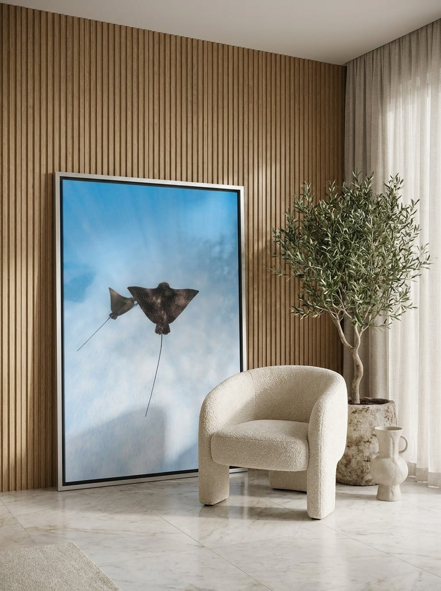 Oversized statement canvas wall art with a silver leaf surround leaning against the wall in a luxe bedroom