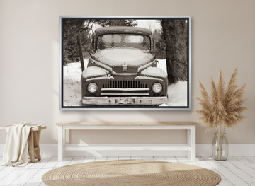 Canvas wall art with a silver leaf surround standing on a console in a coastal home office