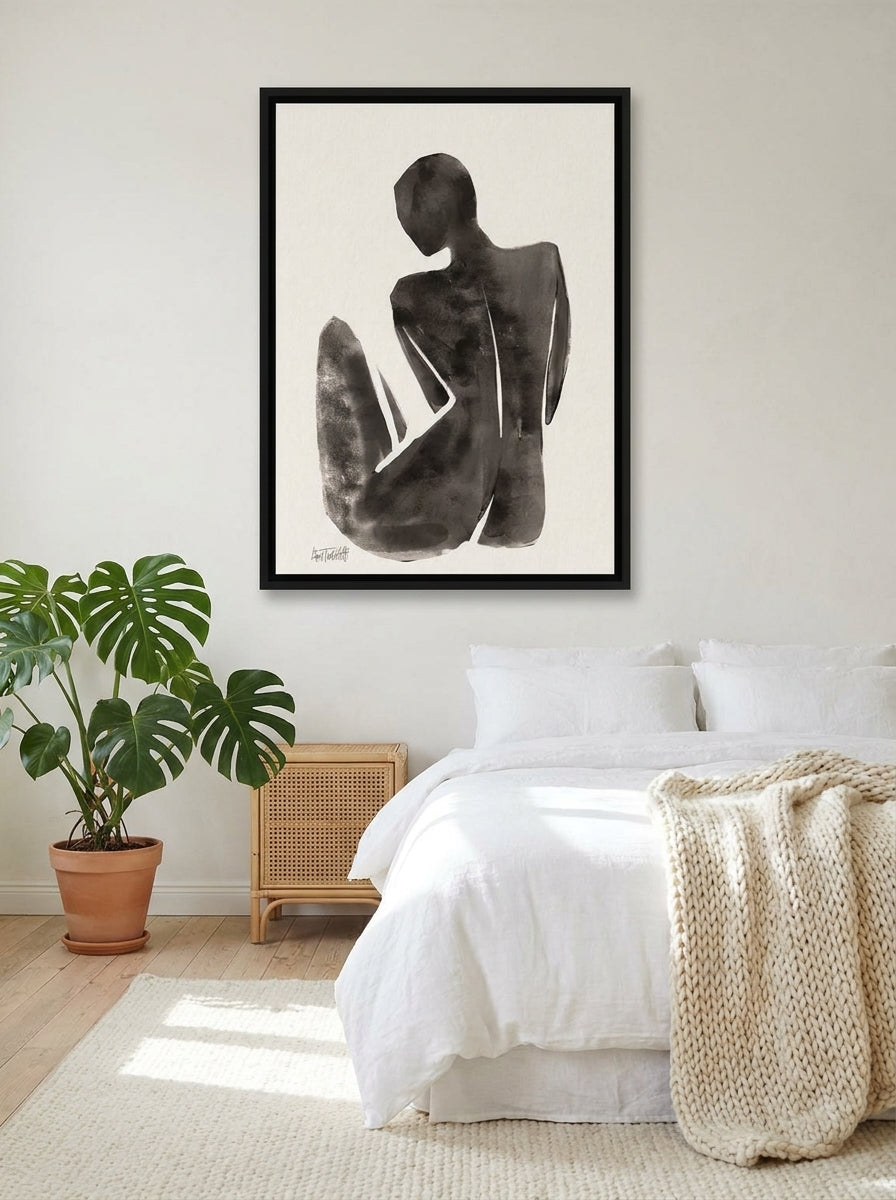 Canvas wall art with a black surround styled on the wall in a bright Scandinavian bedroom