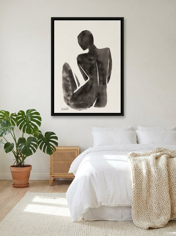 Canvas wall art with a black surround styled on the wall in a bright Scandinavian bedroom