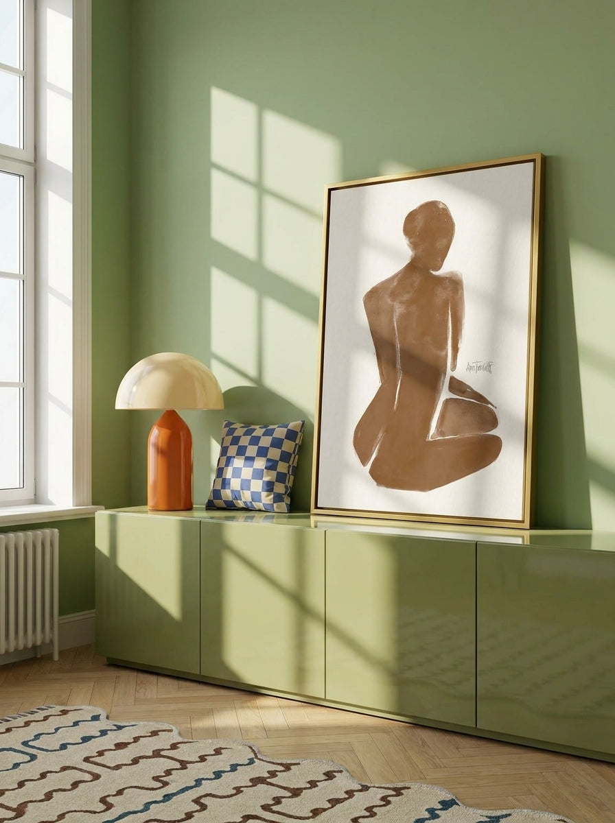 Canvas wall art with a gold leaf surround standing on a sideboard in a colourful eclectic bedroom