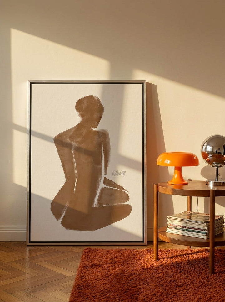 Oversized statement canvas wall art with a silver leaf surround leaning against the wall in a retro 70s living room