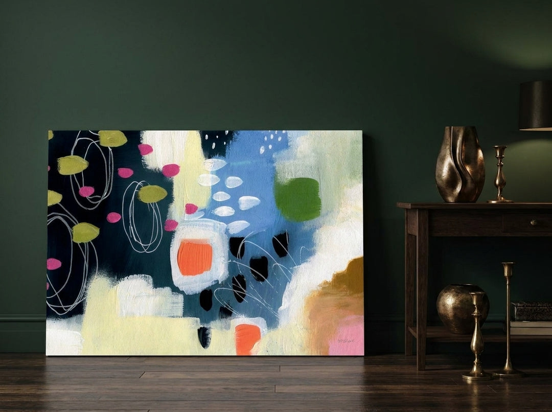 Stretched canvas wall art leaning against the wall in a moody home office