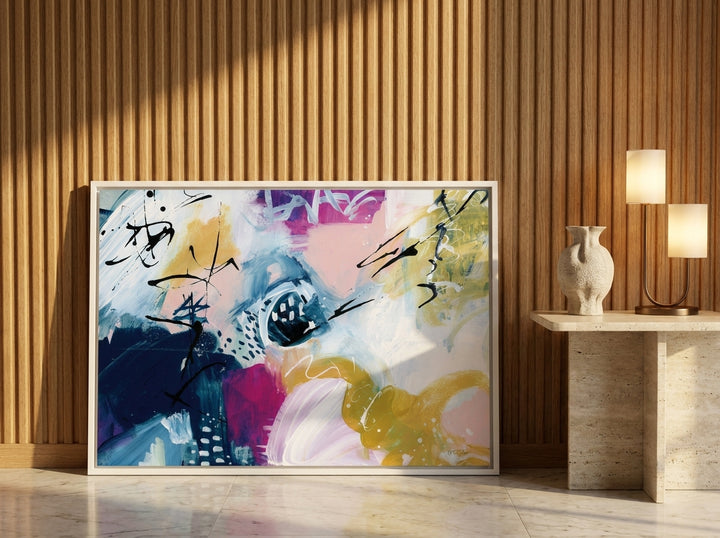 Canvas wall art with a white surround leaning against the wall in a luxe dining room