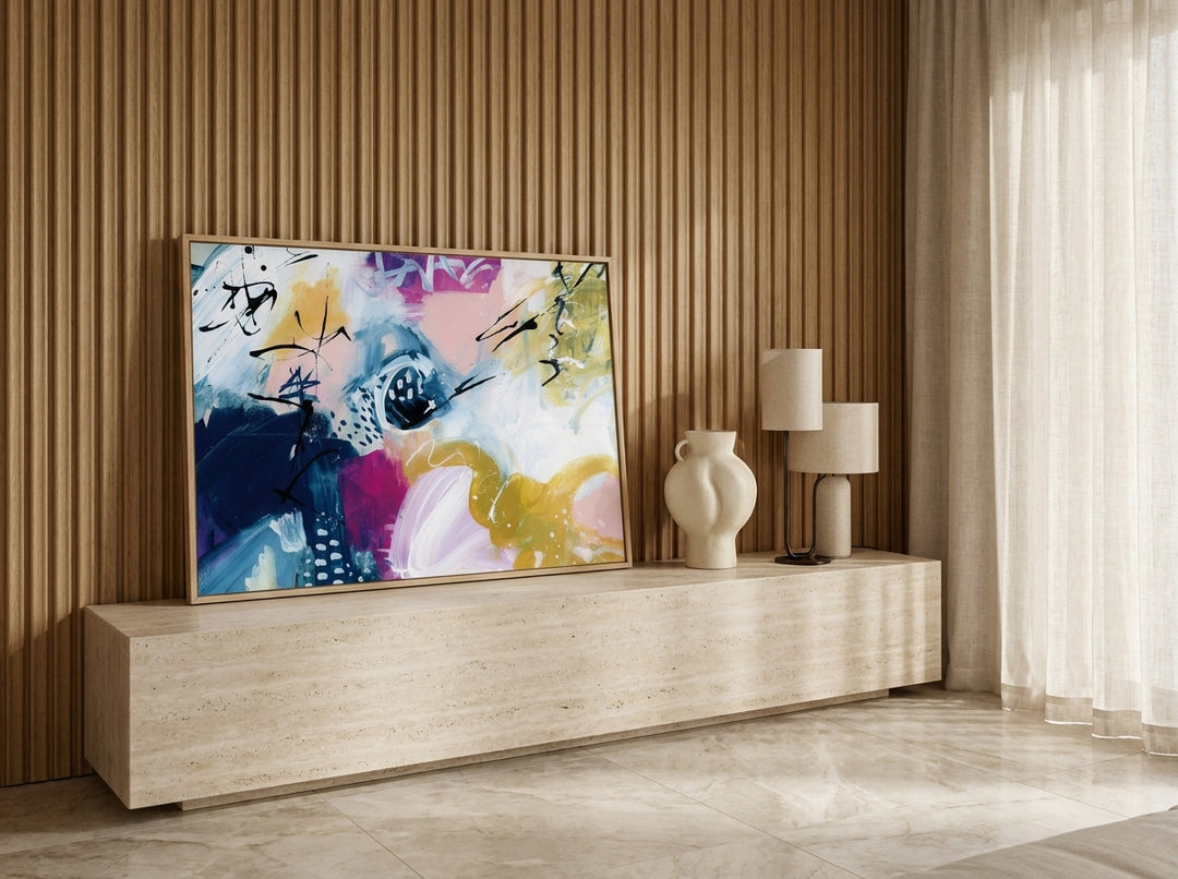 Modern wall art print standing on a console in a luxe bedroom