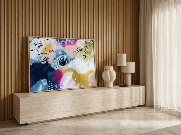 Modern wall art print standing on a console in a luxe bedroom