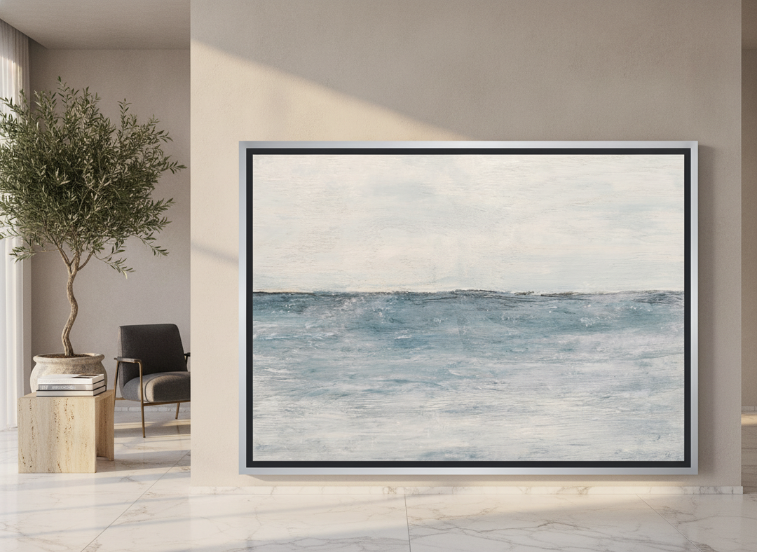 Oversized statement canvas wall art with a silver leaf surround leaning against the wall in a luxe dining room
