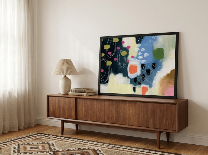 Modern wall art print standing on a sideboard in a mid-century home office