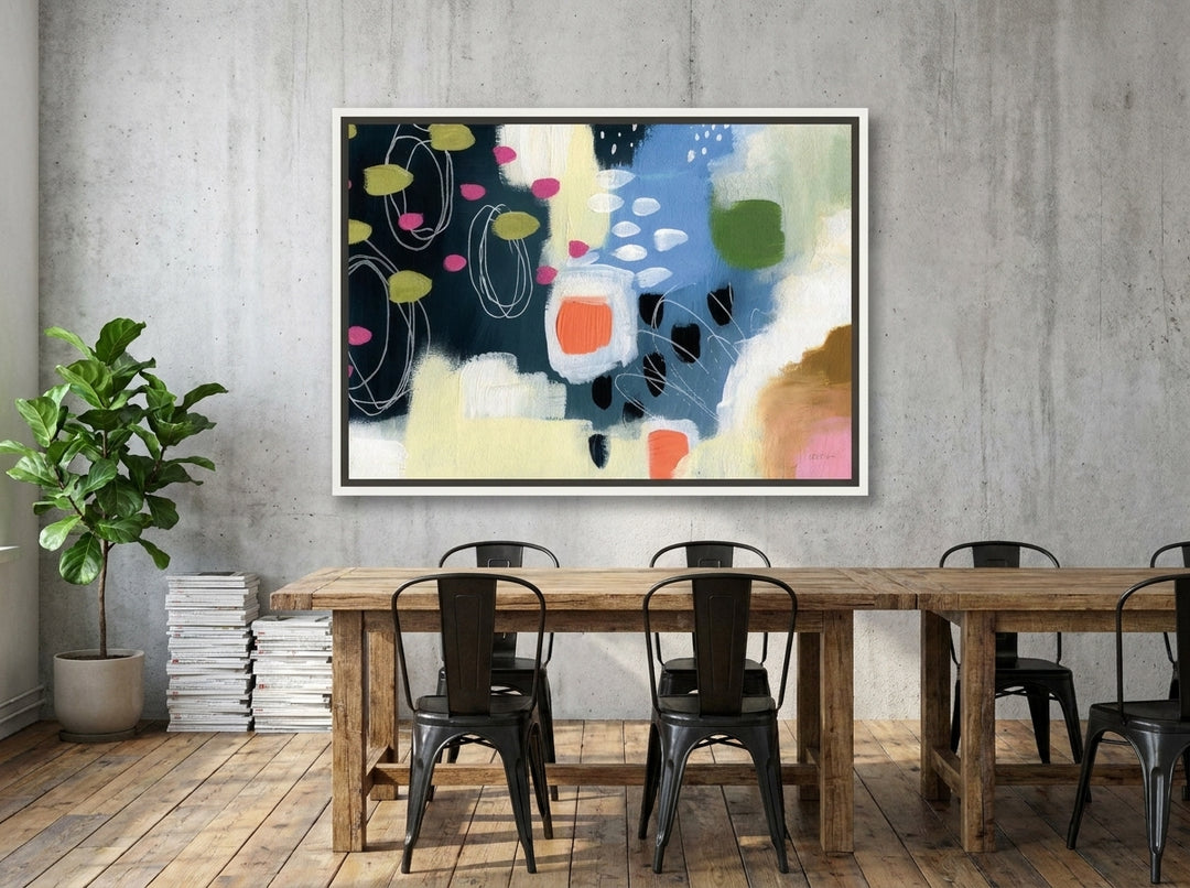 Canvas wall art with a white surround styled on the wall in an industrial loft dining room