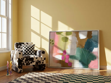 Canvas wall art with a white surround leaning against the wall in a colourful eclectic bedroom