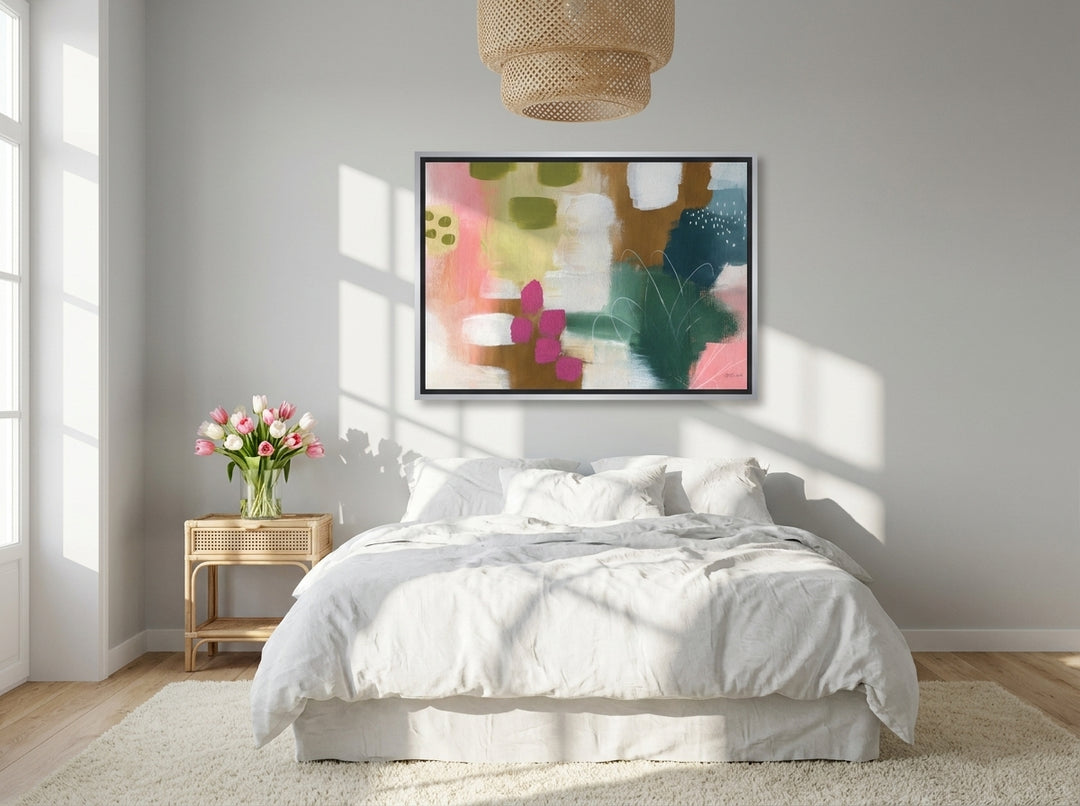 Canvas wall art with a silver leaf surround styled on the wall in a bright Scandinavian bedroom
