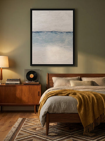 Canvas wall art with a black surround styled on the wall in a mid-century bedroom