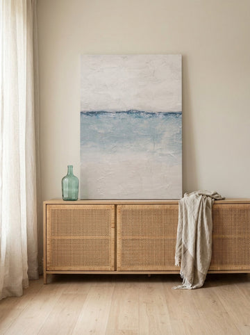 Stretched canvas wall art standing on a sideboard in a coastal living room