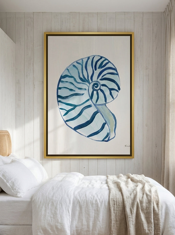 Oversized statement canvas wall art with a gold leaf surround styled on the wall in a coastal bedroom