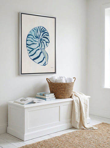 Canvas wall art with a silver leaf surround styled on the wall in a coastal bathroom