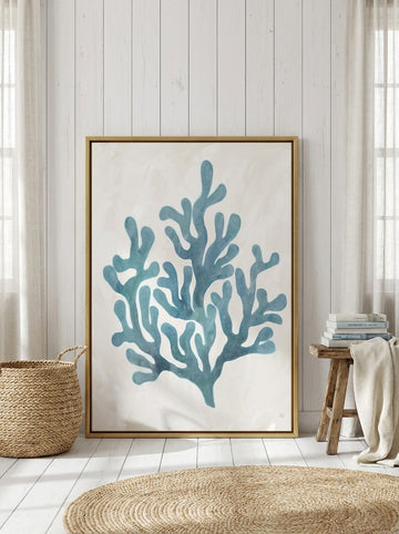 Canvas wall art with a gold leaf surround leaning against the wall in a coastal bedroom