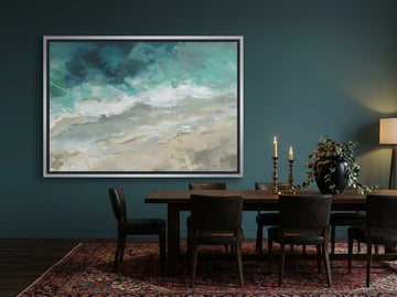 Oversized statement canvas wall art with a silver leaf surround styled on the wall in a moody dining room
