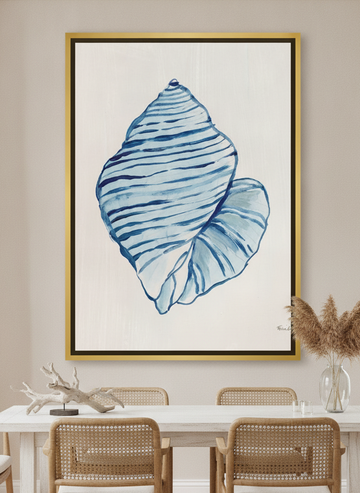 Oversized statement canvas wall art with a gold leaf surround styled on the wall in a coastal dining room