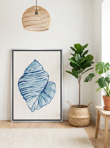 Canvas wall art with a silver leaf surround leaning against the wall in a bright Scandinavian bathroom