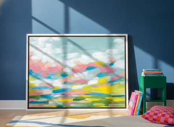 Canvas wall art with a white surround leaning against the wall in a colourful eclectic dining room