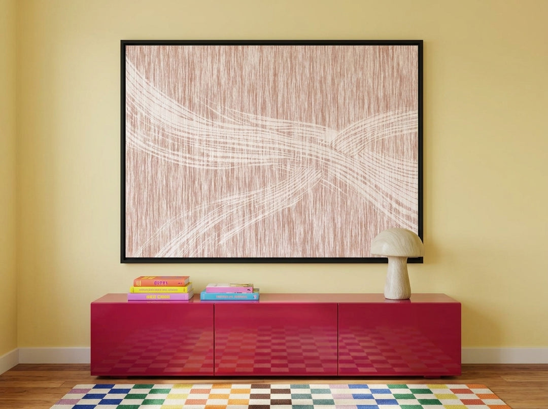 Canvas wall art with a black surround styled on the wall in a colourful eclectic living room