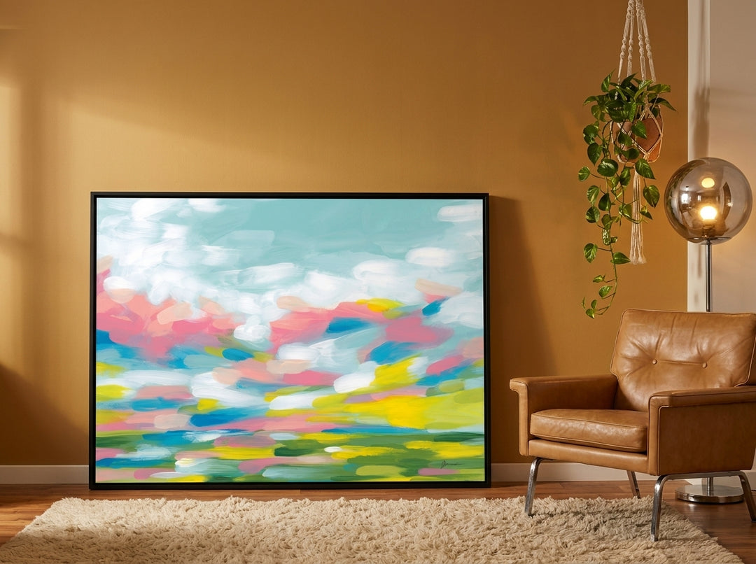 Oversized statement canvas wall art with a black surround leaning against the wall in a retro 70s dining room