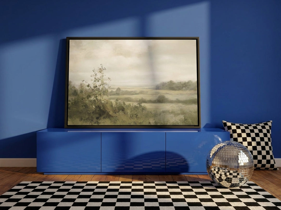 Canvas wall art with a black surround standing on a sideboard in a colourful eclectic living room