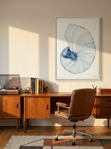 Canvas wall art with a white surround styled on the wall in a mid-century home office