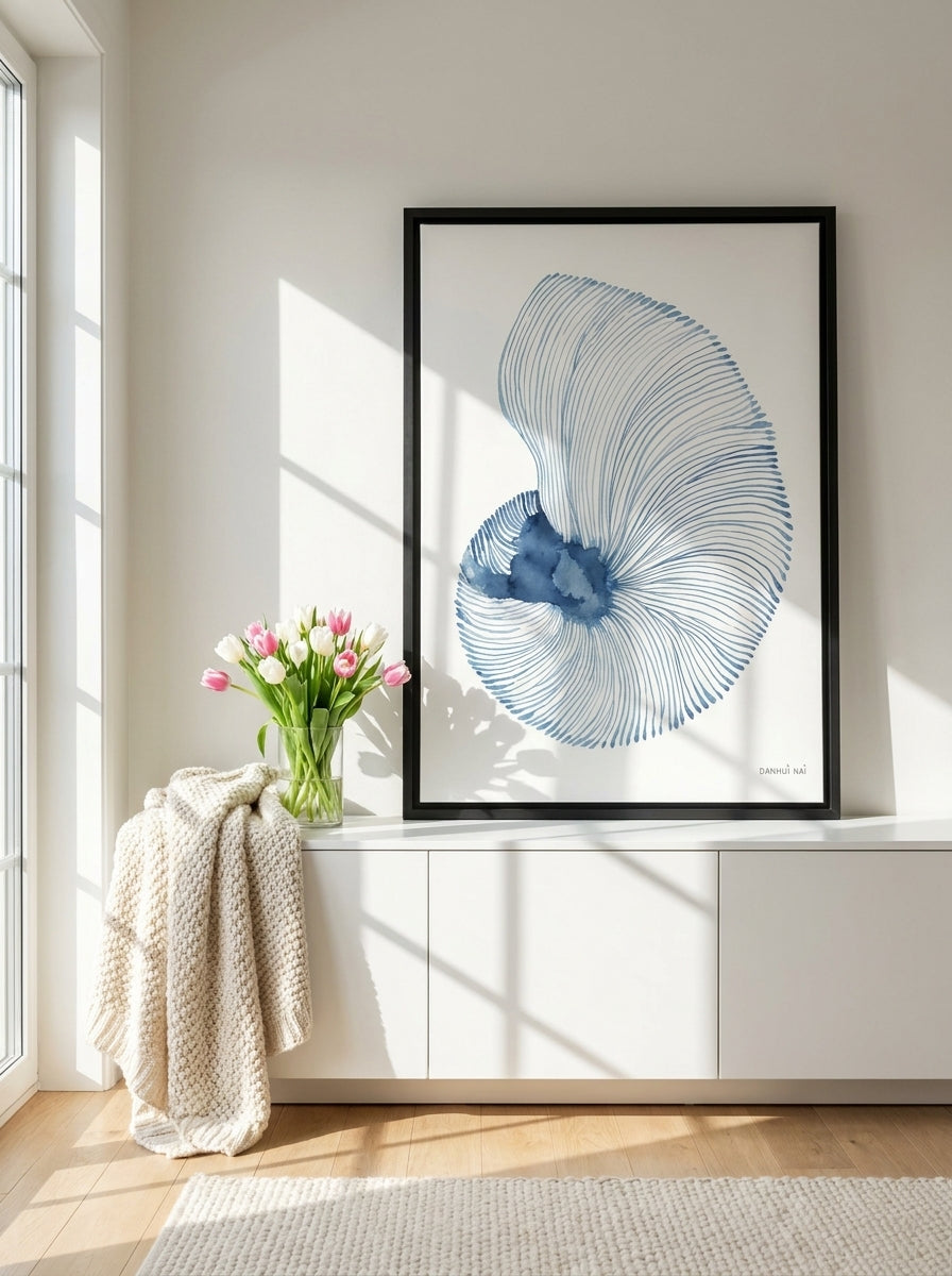 Canvas wall art with a black surround standing on a sideboard in a bright Scandinavian bathroom