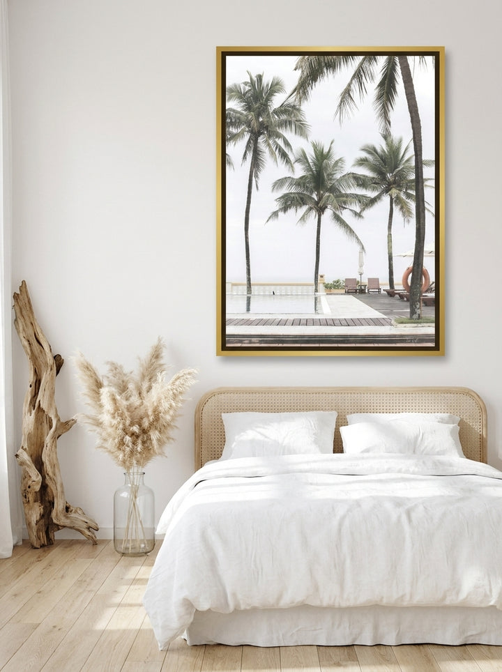 Canvas wall art with a gold leaf surround styled on the wall in a coastal bedroom