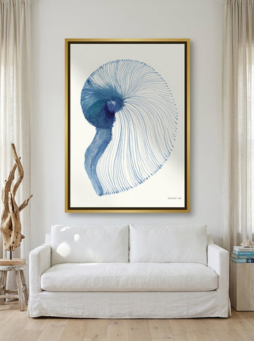 Oversized statement canvas wall art with a gold leaf surround styled on the wall in a coastal living room