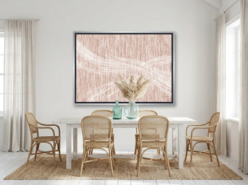 Oversized statement canvas wall art with a silver leaf surround styled on the wall in a coastal dining room
