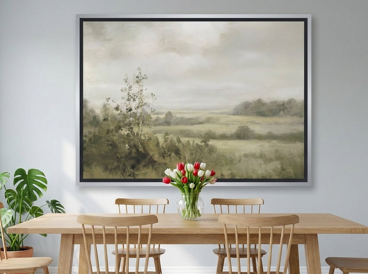 Oversized statement canvas wall art with a silver leaf surround styled on the wall in a bright Scandinavian dining room