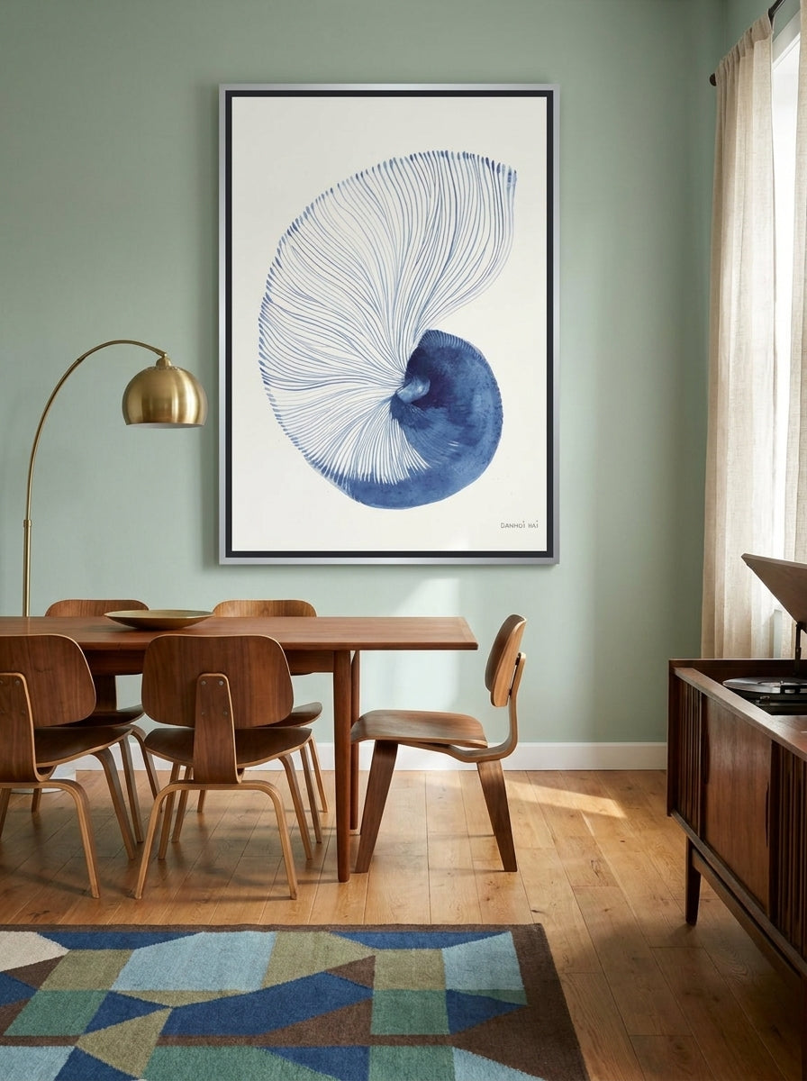 Oversized statement canvas wall art with a silver leaf surround styled on the wall in a mid-century dining room
