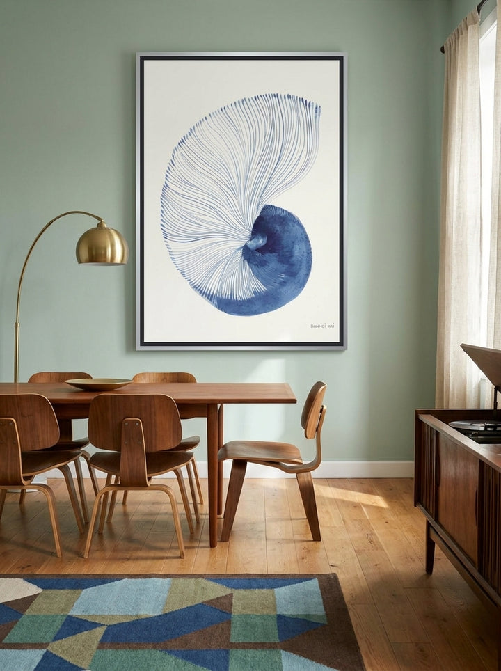 Oversized statement canvas wall art with a silver leaf surround styled on the wall in a mid-century dining room